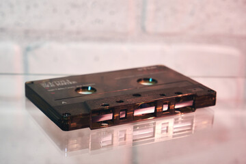 Lying on its side audio cassette without box. Analog format for audio playing and recording