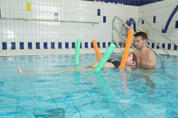 husband and pregnant wife doing exercices in the water