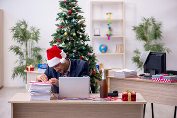 Young male employee celebrating new year in the office