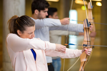 row of people aiming with their archery bows
