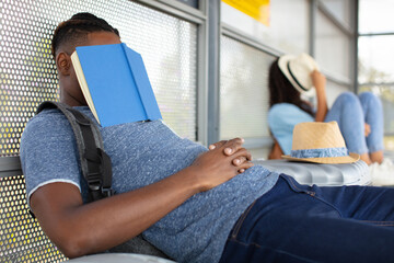 students resting on the floor with books on their faces