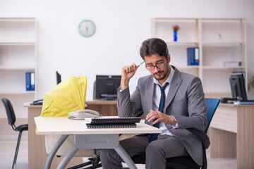 Young male employee looking after new born at workplace