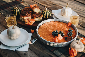 Thanksgiving festive table. Autumn style table setting with pumpkins, leaves and physalis. Pumpkin...