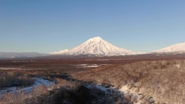 4K Aerial footage of three famous volcanoes in Kamchatka, Russia. Cones of Koryaksky volcano, Avachinsky volcano and Kozelskiy volcano. Kamchatka nature in winter.