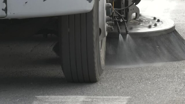 Closeup of a street sweeper approaching as it cleans the road