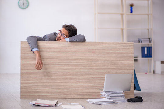 Young male employee working overtime in the office