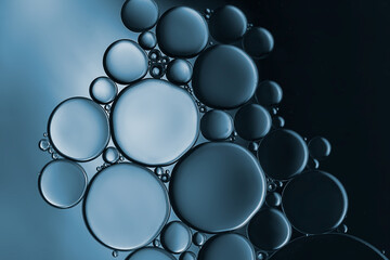 Closeup of water and oil droplets on dark blue  background.	