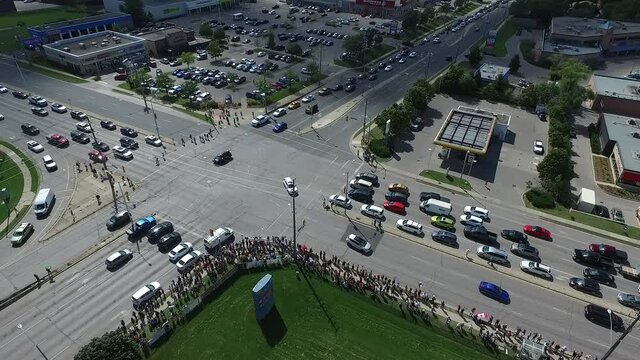 Descending Aerial Street Corner Protestors Demonstrators Against Injections With Signs About Vaccine Deaths