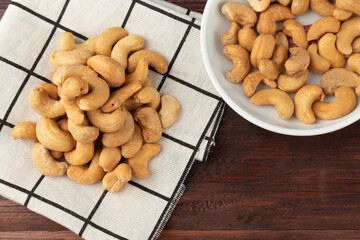 Cashew nuts in tablecloth on wooden table, Healthy snack, Vegetarian food.