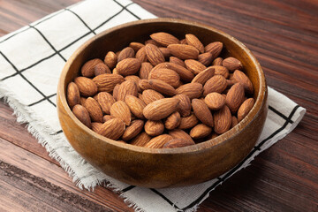 Almonds in wooden bowl on the table, Healthy snack, Vegetarian food.