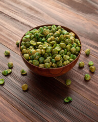 Salted green peas in wooden bowl on the table, Healthy snack, Vegetarian food.