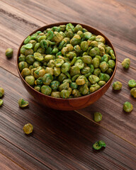 Salted green peas in wooden bowl on the table, Healthy snack, Vegetarian food.