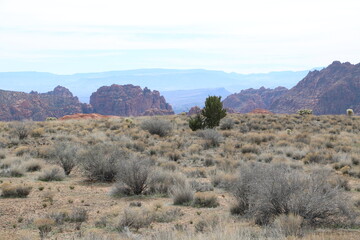 Sagebrush flats of Great Basin give way to red rocks and hot desert of the Mojave in the distance,...
