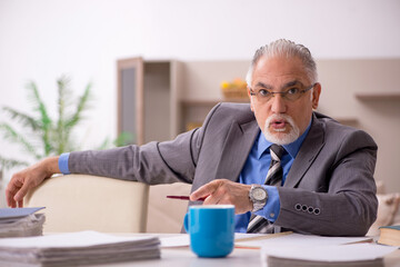 Old male employee working from home during pandemic