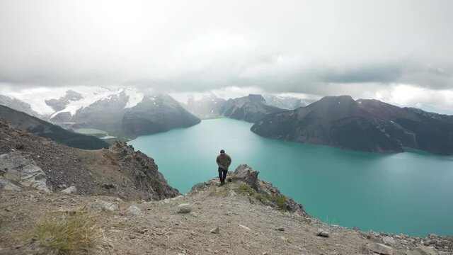 Man On Hilltop With Turquoise Lake At Garibaldi Provincial Park In British Columbia, Canada. Wide Shot