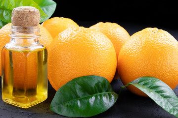 Natural organic Orange essential oil in a glass bottle.Fresh Orange fruits with green leaves. Healthy vegan food. Vitamins food.Ripe oranges.