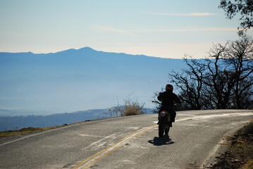 Motorcyclist on a mountain road in fall