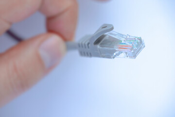 A person holding a Ethernet patch Internet cable for wired home and office networks