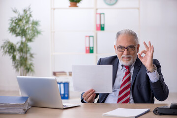 Old male employee working in the office