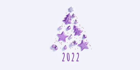 Fototapeta na wymiar Christmas tree from christmas glitter toys, minimal New Year composition lavender color, copy space. New Year holiday banner with bright celebration decorations. Flat lay
