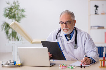 Old male doctor pharmacist working at the lab