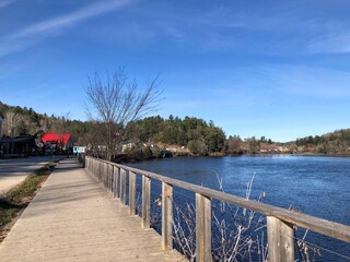 A beautiful boardwalk path along the Gatineau River on a beautiful sunny fall day in pretty town of Wakefield, Quebec, Canada.