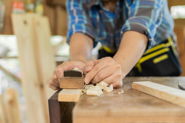 Carpentry professional, asian young man, male carpenter use machines or tool, shavings rugged on...