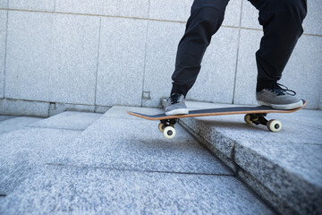 Skateboarder riding  skateboard goring down the stairs outdoors in city