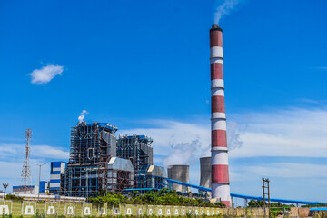 the chimneys of the thermal power station with white clouds of steam and Cooling tower of thermal power plant at neyveli, India