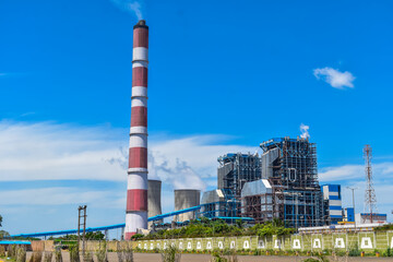 the chimneys of the thermal power station with white clouds of steam and Cooling tower of thermal power plant at neyveli, India