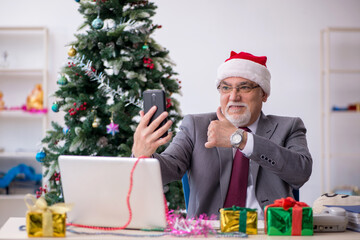 Aged male employee celebrating Christmas at workplace