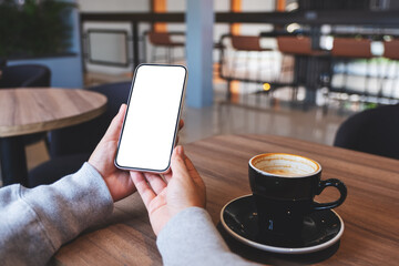 Mockup image of hands holding mobile phone with blank desktop screen