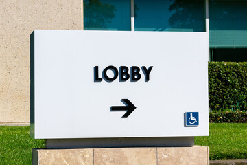 Lobby sign with an arrow directs company customers, visitors and vendors in the right direction