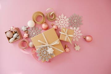 Obraz na płótnie Canvas Christmas background with gift box in pink colors. Xmas celebration, greetings, preparation for winter holidays. Festive mockup, top view, flat lay with copy space.