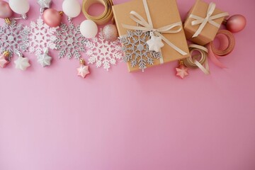 Christmas background with gift box in pink colors. Xmas celebration, greetings, preparation for winter holidays. Festive mockup, top view, flat lay with copy space.