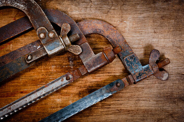 Old vintage metal hacksaws for metal shot on a wooden background.