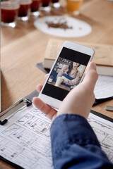 Hand with smart phone screen against wooden table