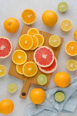 Colorful juicy summer oranges, grapefruits, limes, lemons on wooden board