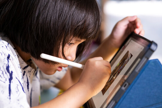 Little Girl Using A Digital Pen And Drawing On Tablet Touch Screen Pad With Digital Pencil To Be Creative And To Make Digital Art And Learning In Home