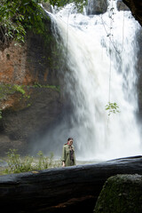 People watch the beautiful nature with trees and mountains, waterfalls. It is a tourist destination for a vacation.