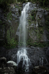 Fototapeta na wymiar A waterfall drops down a cliff in the mountains