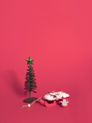Christmas tree and Santa´s sleigh stand on pastel red background. Minimal vertical composition,  Christmas and New Year abstract decorative  concept..