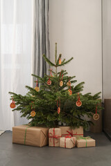 Small christmas tree with natural decorations and gift boxes