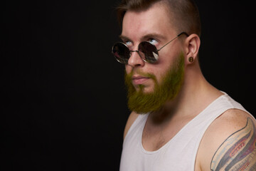 handsome man with tattoos on his arms fashion sunglasses dark background