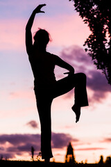 silhouette from a ballet dancer during the dusk or sunset happy positive motion with music 