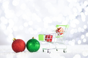 christmas sale,trolley cart with gifts and presents and decoration balls on background of a Christmas lights with copy space