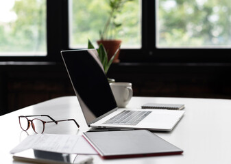 Fototapeta premium Workplace, laptop computer and glasses at office desk, business, online learning, working from home, place of work at home office, freelance concept.