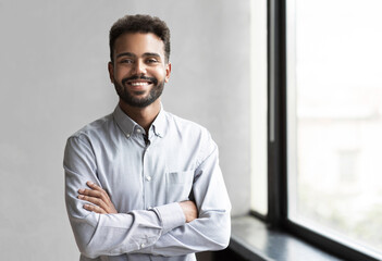 Confident young businessman office portrait, Mixed race latin man smiling indoor