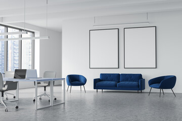 Two mockups and accent blue seating area in grey and white office