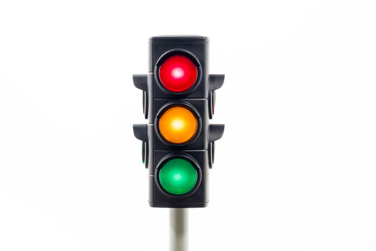 Isolated traffic light showing an illuminated red, amber and, green light.  Concept image illustrating control of the COVID pandemic and confusion with movement between levels.

